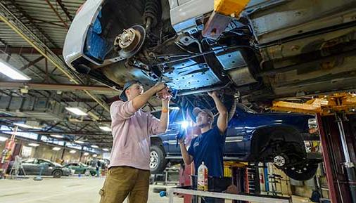 学生们在汽车实验室里研究一辆汽车